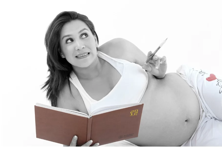 Бременна жена чете и си води записки. Информираността е важна при внезапно изтичан на околоплодни води.