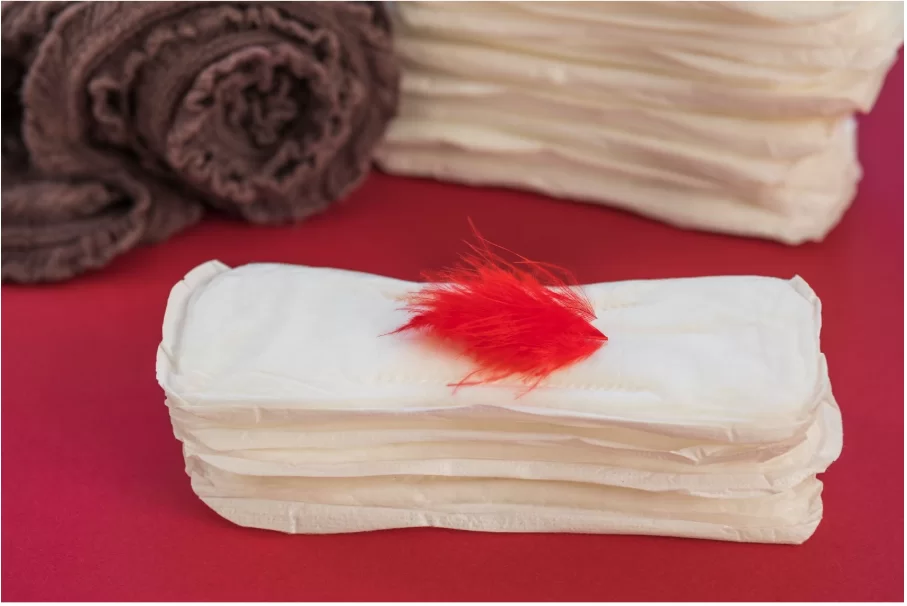 Купчина дамски превръзки с червено перо върху тях.