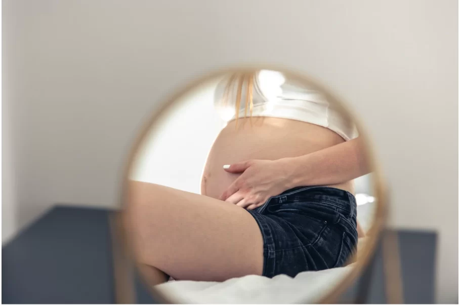 Отражение на корема на бременна жена в огледало